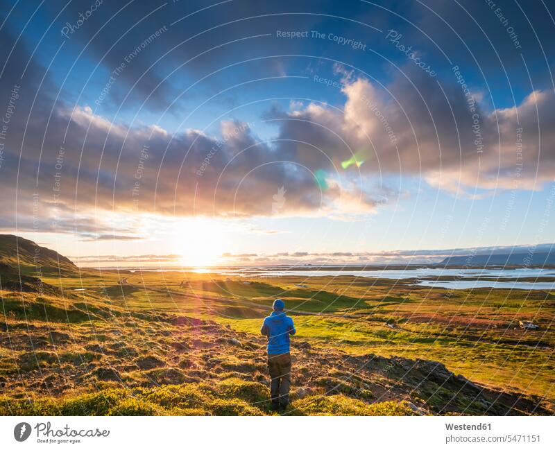 Male hiker admiring sunset over Snaefellsnes peninsula, Iceland outdoors location shots outdoor shot outdoor shots sunsets sundown atmosphere Idyllic