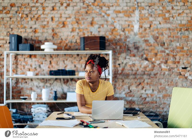 Young woman sitting at table using laptop human human being human beings humans person persons African black black ethnicity coloured 1 one person only