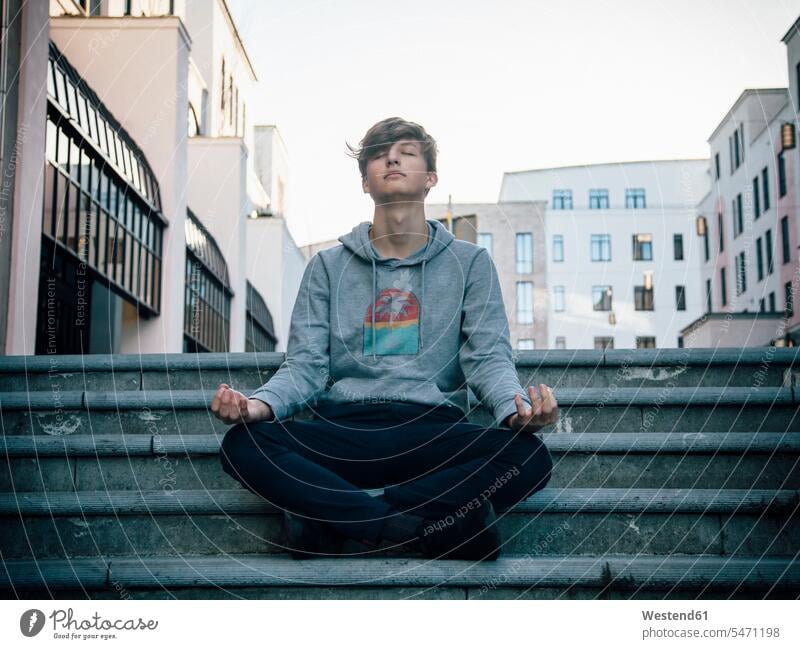 Teenager sitting on steps meditating in the city headphone headset relax relaxing smile Seated happy Contented Emotion pleased free time leisure time Lifestyle