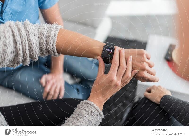 Woman's hand adjusting smartwatch at desk setting smart watch human hand hands human hands woman females women people persons human being humans human beings
