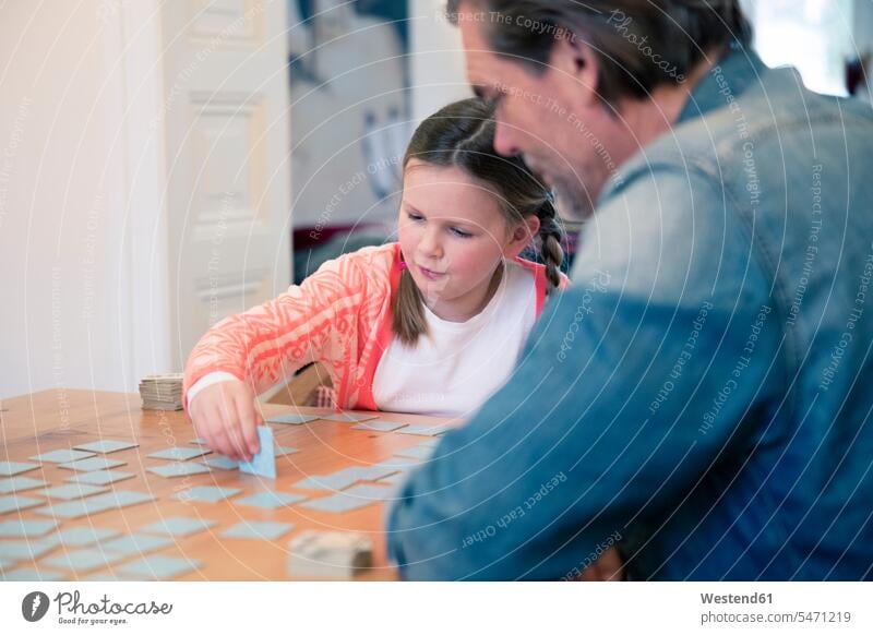 Father and daughter playing memory on table at home daughters father pa fathers daddy dads papa Table Tables child children family families people persons