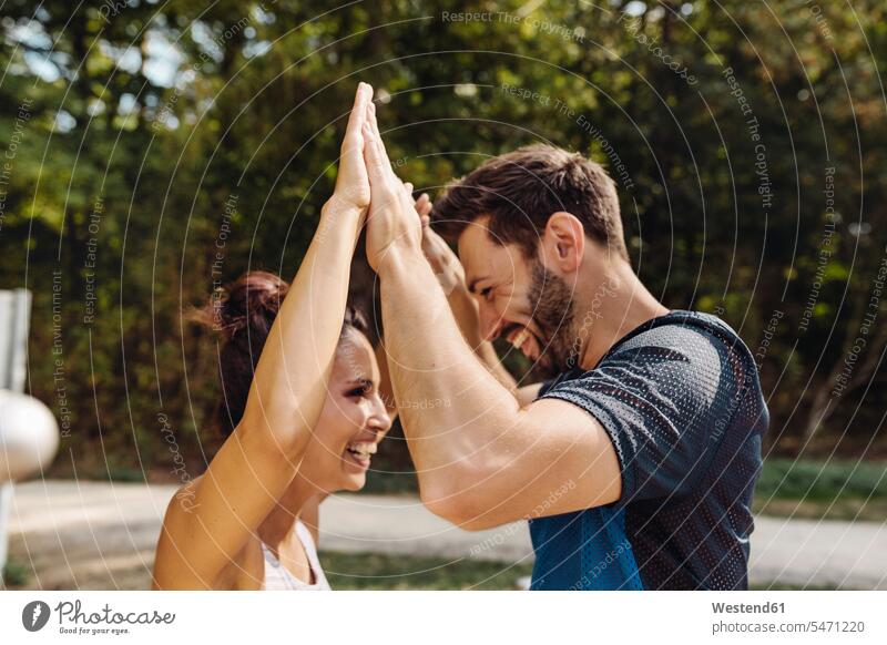 Man and woman high-fiving on a fitness trail human human being human beings humans person persons caucasian appearance caucasian ethnicity european Mixed Race