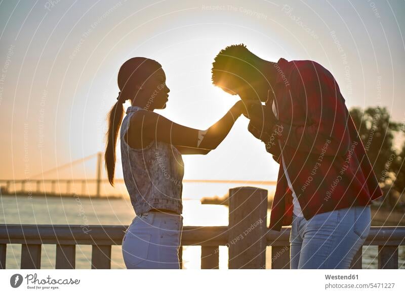 Young couple holding hands at sunset human human being human beings humans person persons African black black ethnicity coloured 2 2 people 2 persons two