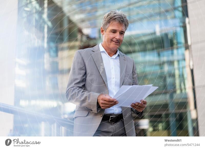 Mature businessman reviewing documents in the city human human being human beings humans person persons caucasian appearance caucasian ethnicity european 1