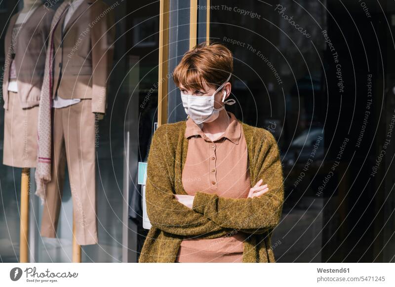Woman wearing mask standing in front of her closed clothing store Occupation Work job jobs profession professional occupation business life business world