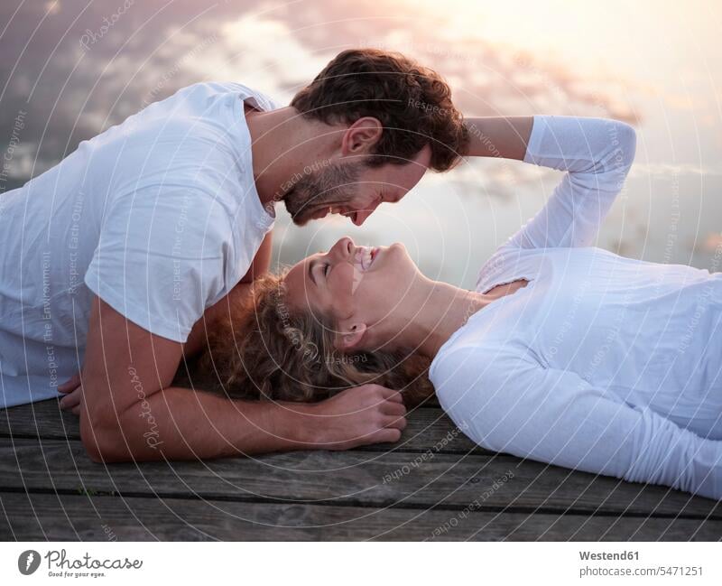 Romantic couple lying on jetty, kissing kisses seasons spring season Spring Time springtime happy Emotions Feeling Feelings Sentiment Sentiments loving