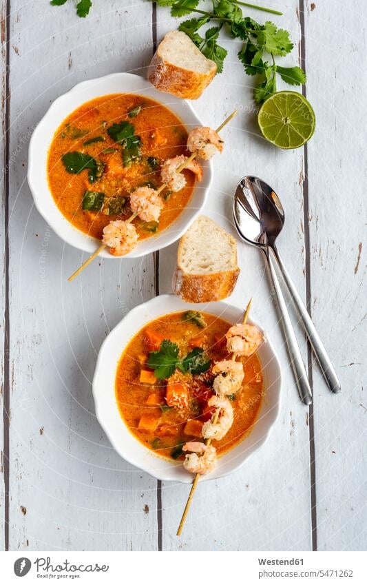Two bowls of sweet potato soup with shrimps, coconut flakes and fresh coriander Bowl Bowls ginger cilantro Coriandrum sativum garnished sliced ready to eat