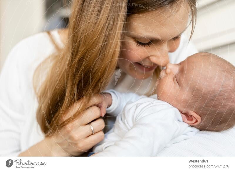 Close-up of smiling mother rubbing nose with sleeping baby boy at home color image colour image indoors indoor shot indoor shots interior interior view