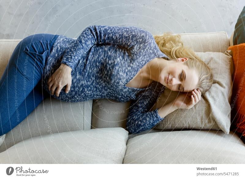 Pregnant woman sleeping on couch at home pregnant Pregnant Woman asleep females women portrait portraits lying laying down lie lying down settee sofa sofas