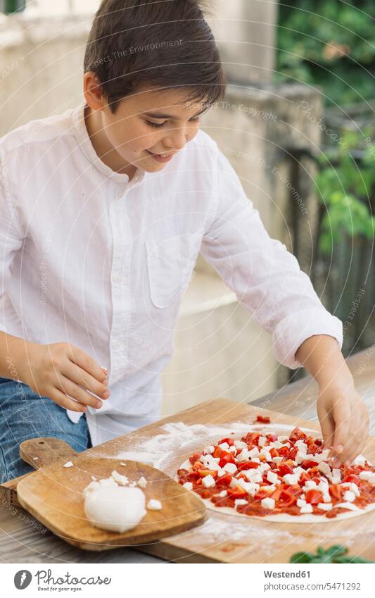 Boy prepairing pizza shirts cook smile delight enjoyment Pleasant pleasure happy pleased at home traditional Traditions Alimentation food Food and Drinks