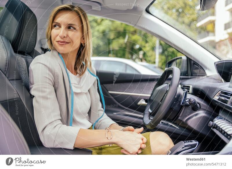 Portrait of smiling woman with protective mask sitting in car motor vehicles road vehicle road vehicles Auto automobile Automobiles cars motorcar motorcars