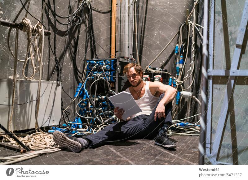 Actor with script rehearsing backstage man men males manuscripts sitting Seated portrait portraits actor actors thespians performer performers Adults grown-ups