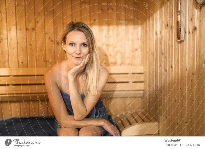 Beautiful woman with hand on chin relaxing in sauna Germany indoors indoor shot indoor shots interior interior view Interiors color image colour image
