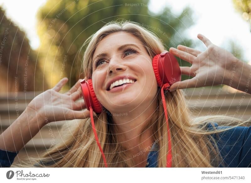 Portrait of smiling woman, listening to music on red headphones human human being human beings humans person persons caucasian appearance caucasian ethnicity