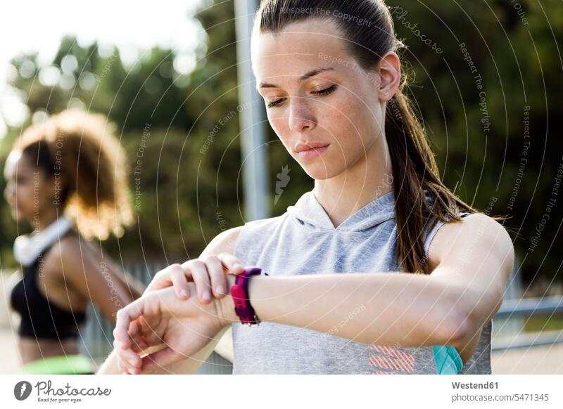 Sporty teenage girl checking her smartwatch human human being human beings humans person persons caucasian appearance caucasian ethnicity european 2 2 people