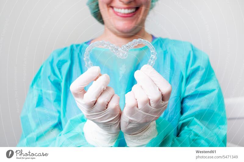 Close-up of nurse holding dental aligners in heart shape at clinic color image colour image indoors indoor shot indoor shots interior interior view Interiors