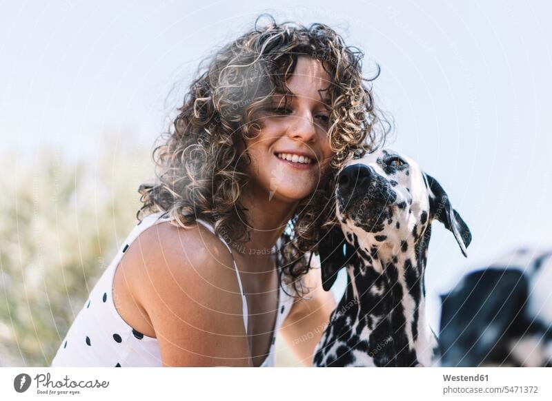 Smiling young woman with Dalmatian dog during sunny day color image colour image pet owner Pet Owners owners outdoors location shots outdoor shot outdoor shots