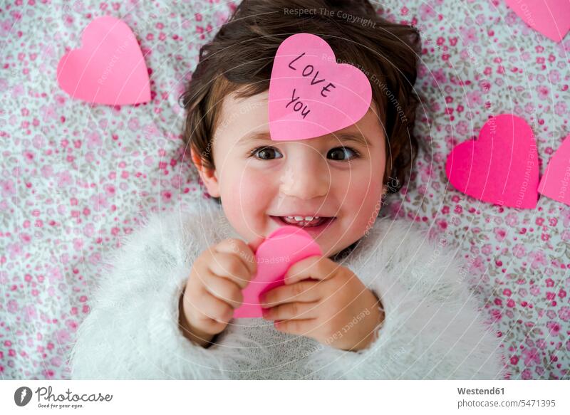 Portrait of baby girl with pink heart-shaped post it stickers baby girls female hearts heart shapes portrait portraits babies infants people persons human being