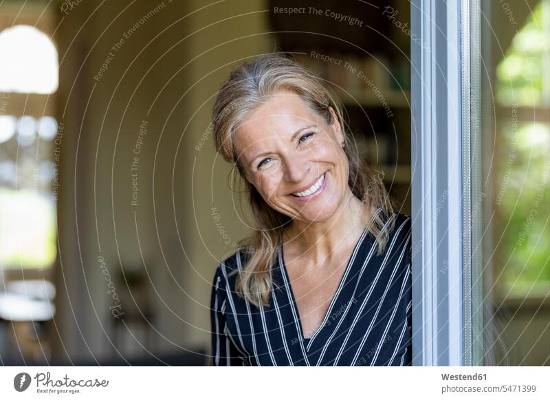 Portrait of smiling mature woman standing at opened terrace door human human being human beings humans person persons caucasian appearance caucasian ethnicity