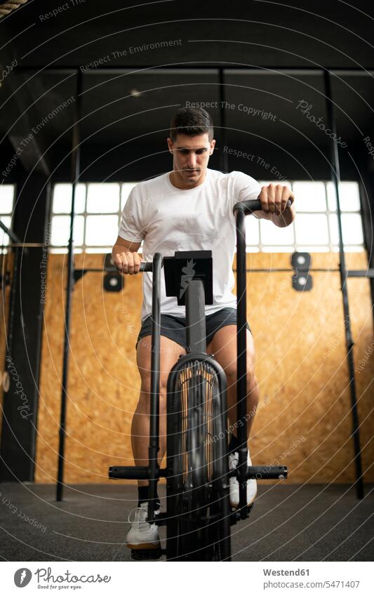 Athletic man doing air bike workout at gym transport bikes cycle cycles bicycles Cycle - Vehicle sports fit free time leisure time Recreational Activities