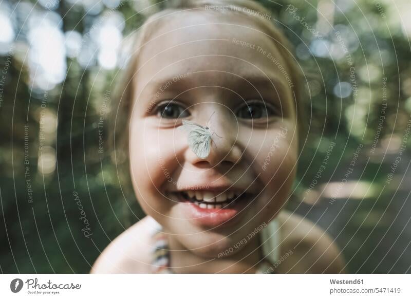 Portrait of smiling little girl with butterfly on her nose butterflies lepidoptera portrait portraits females girls noses smile insect hexapoda insects insecta