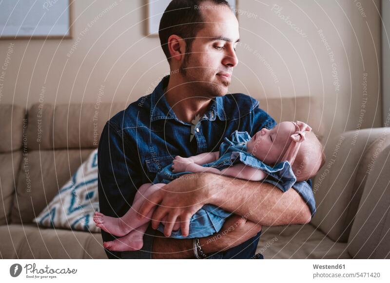 Father carrying sleeping baby girl on sofa at home color image colour image indoors indoor shot indoor shots interior interior view Interiors day daylight shot