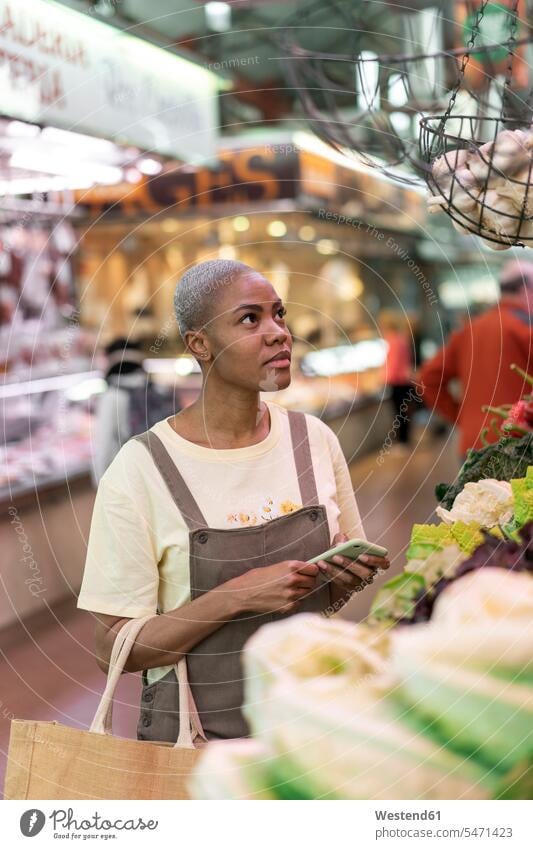 Woman buying groceries in a market hall human human being human beings humans person persons client clientele clients customers short hairs short hairstyle
