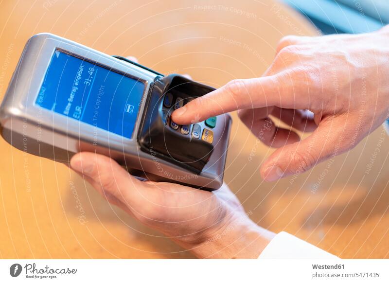 Man using credit card reader, close-up Germany entering digitization digitazing digitalisation digitalization On Part Of partial view cropped Cardkey Reader