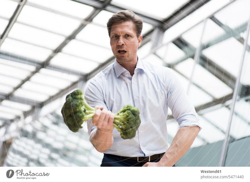 Businessman doing weight training with broccoli human human being human beings humans person persons caucasian appearance caucasian ethnicity european 1