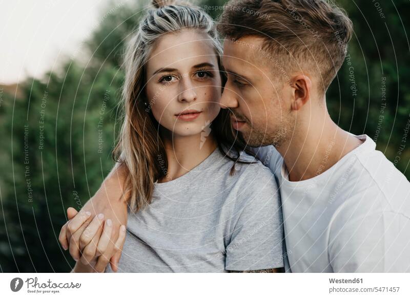 Portrait of young couple, arm around embrace Embracement hug hugging in the evening happy Emotions Feeling Feelings Sentiment Sentiments loving closeness