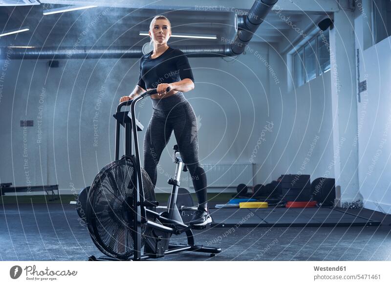 Athletic woman doing air bike workout at gym exercise exercises Airbike Airbikes sportive sporting sporty athletic gyms Health Club females women sports fitness