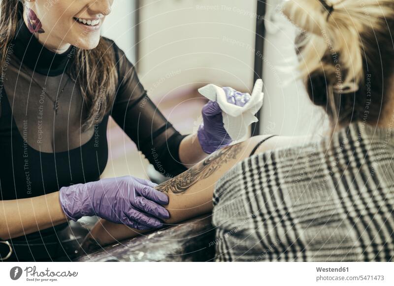 female tattooist tattooing upper arm of female customer human human being human beings humans person persons arms shoulders Changes Changing Occupation Work job