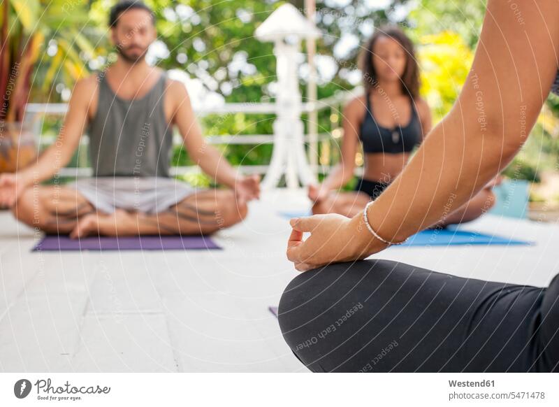 Two women and a man practicing yoga on terrace practice practise exercise exercising practising terraces mindfulness aware awareness self-care