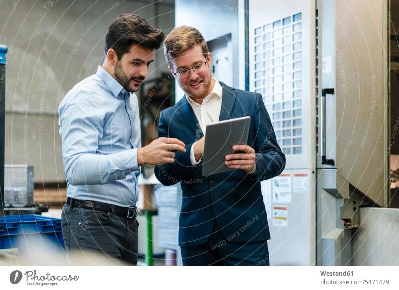 Smiling businessmen using digital tablet at industry color image colour image indoors indoor shot indoor shots interior interior view Interiors Austria
