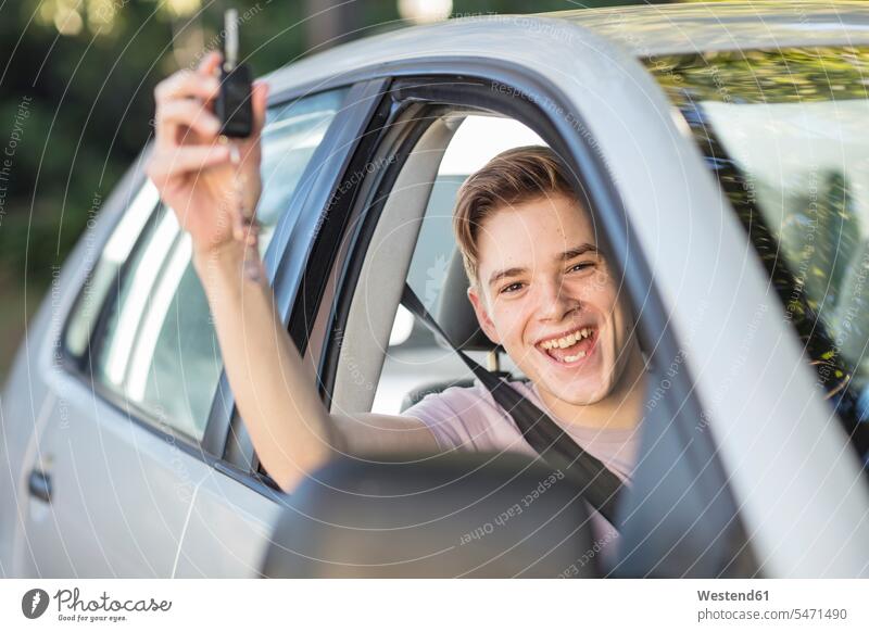 Happy learner driver cheering and holding car key automobile Auto cars motorcars Automobiles student driver happiness happy car keys jubilate rejoicing rejoice