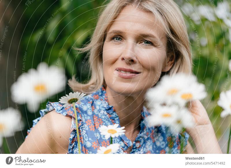 Portrait of smiling mature woman with flowers Flower Flowers smile females women portrait portraits Plant Plants Adults grown-ups grownups adult people persons
