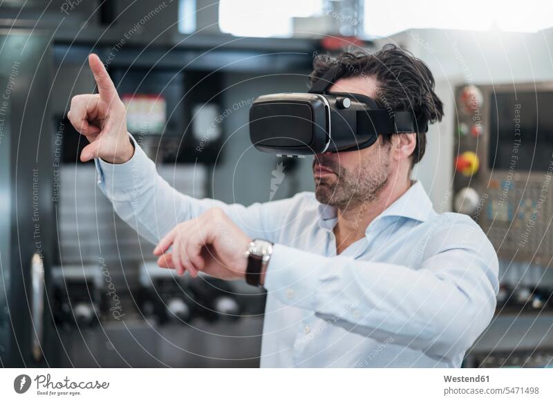Businessman using VR glasses in a factory human human being human beings humans person persons caucasian appearance caucasian ethnicity european 1