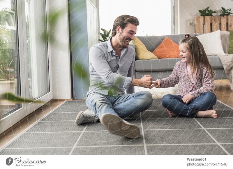 Young man and little girl sitting at home, playing paper scissors stone optimistic optimism Paper Scissors Stone Rock Paper Scissors full length full-length