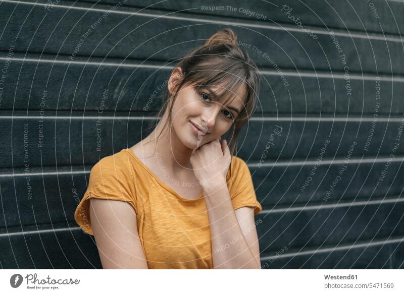Portrait of a pretty woman in front of roller shutter amiable likeable natural naturally portrait portraits Prettiness females women liking sympathy Adults