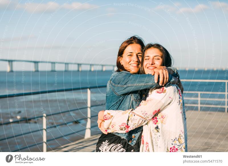 Happy mother embracing daughter while standing against sea color image colour image Portugal leisure activity leisure activities free time leisure time