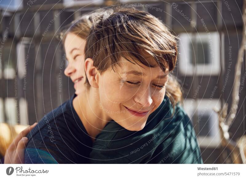 Mother and daughter at home hugging at the window windows cuddle snuggle snuggling smile embrace Embracement relax relaxing relaxation Secure enjoy enjoyment