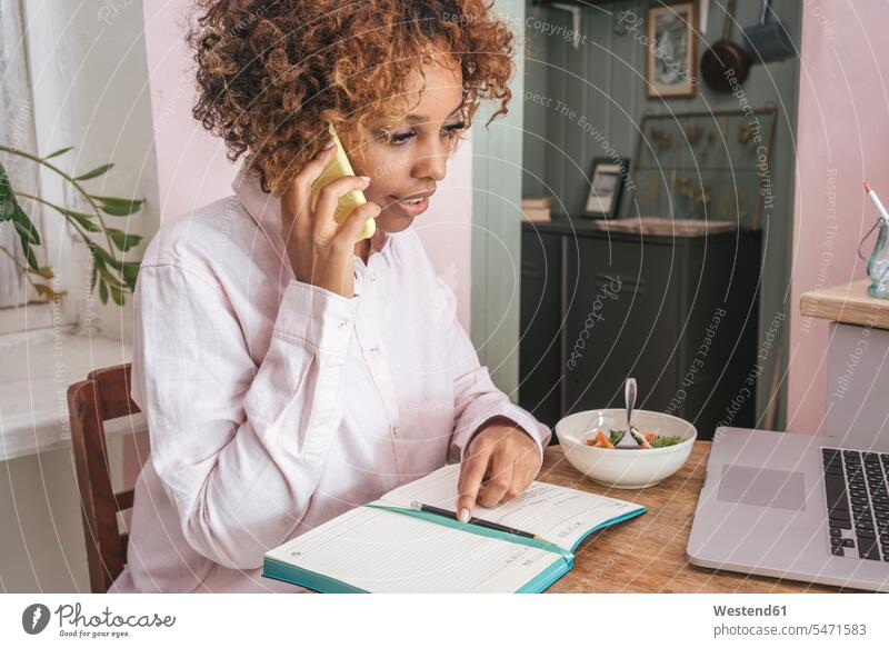 Young woman working at home talking on the phone human human being human beings humans person persons African black black ethnicity coloured 1 one person only