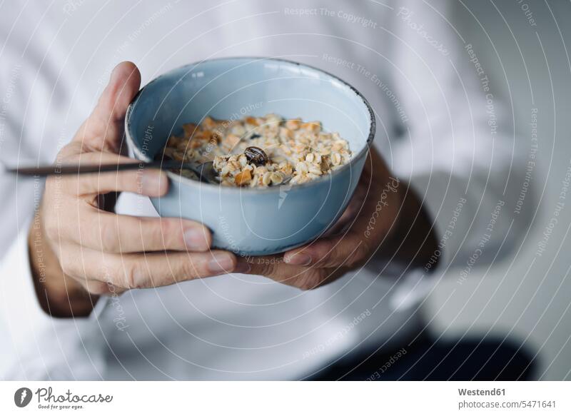 Man's hands holding cereal bowl, close-up Crockery Tableware Bowls flatware Spoons Alimentation food Food and Drinks Nutrition foods Meal cereals Muesli indoor