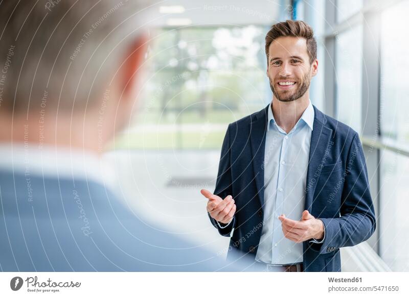 Portrait of a businessman in a passageway talking to colleague human human being human beings humans person persons caucasian appearance caucasian ethnicity
