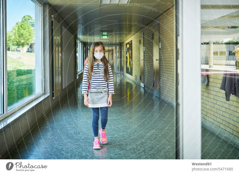 Girl wearing mask walking on school corridor pupils schoolchild schoolchildren go going healthy protect protecting safe Safety secure buildings schools