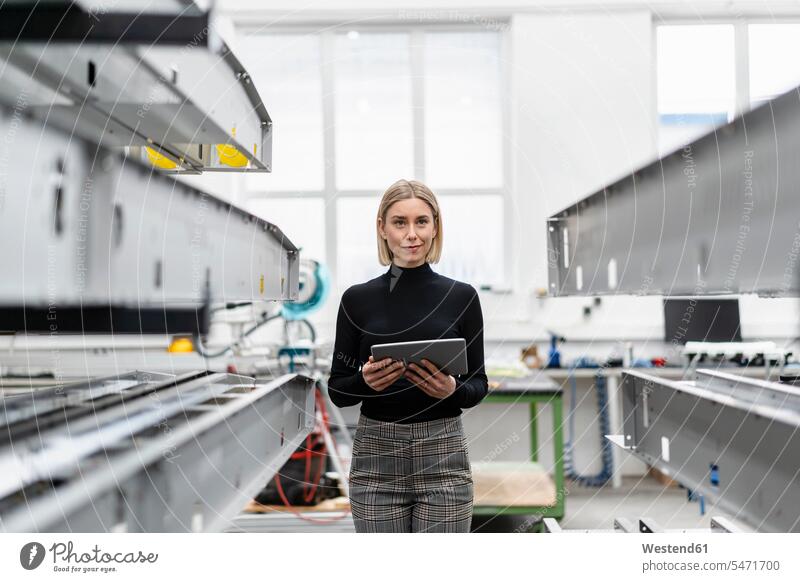 Woman holding tablet at metal rods in factory hall Occupation Work job jobs profession professional occupation business life business world business person