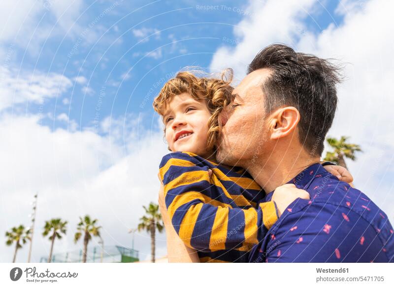 Spain, Barcelona, father kissing son on the beach beaches sons manchild manchildren fathers daddy dads papa kisses family families people persons human being