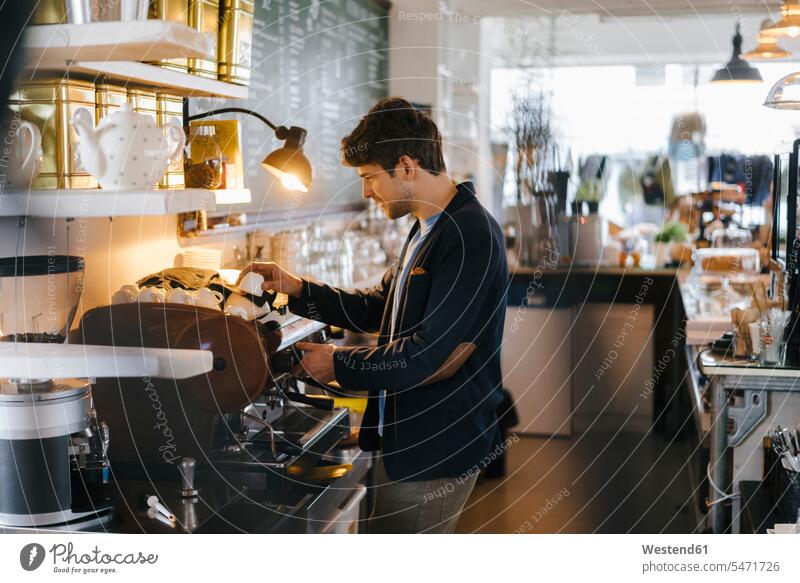 Man in a cafe sorting cups man men males Coffee Cup Coffee Cups Adults grown-ups grownups adult people persons human being humans human beings Dishes Crockery