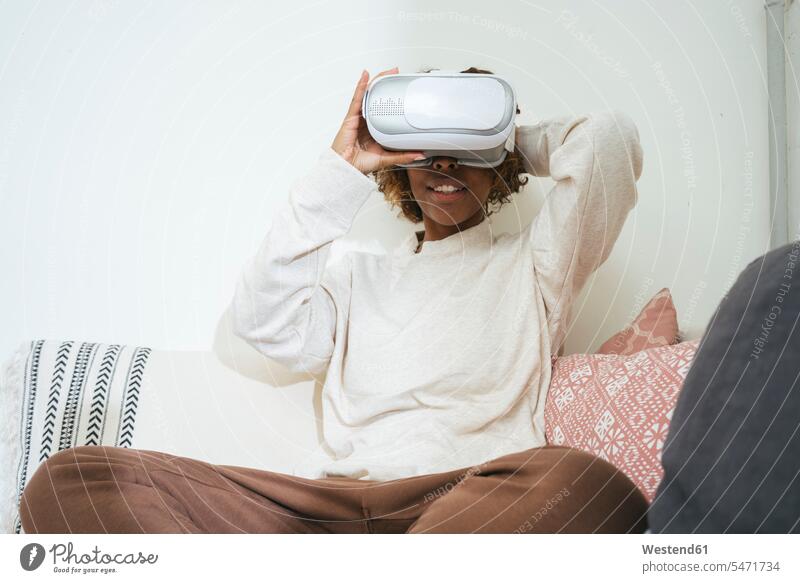 Young woman at home wearing VR glasses human human being human beings humans person persons African black black ethnicity coloured 1 one person only