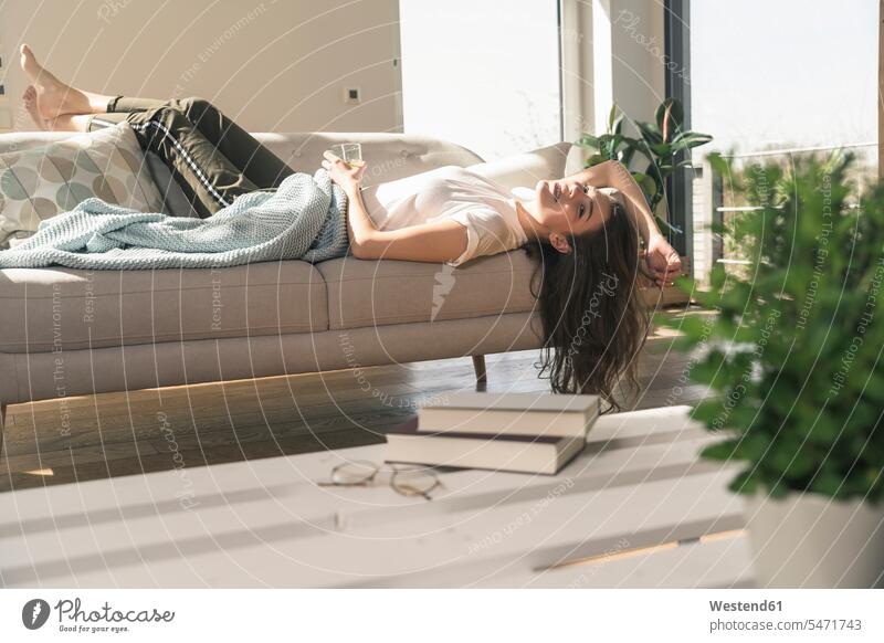 Relaxed young woman lying on couch Germany flat flats apartment apartments getting away from it all Getting Away From All unwinding relaxing Wellbeing